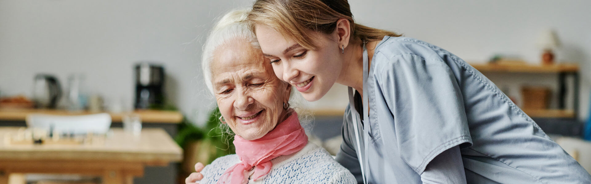elderly with her caregiver hugging